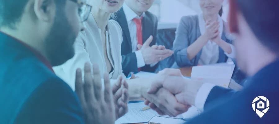 A group of real estate executives coming to a deal and applauding