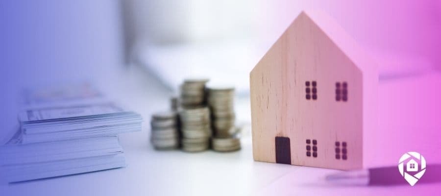 Picture of a wooden house next to money on a desk for what is a real estate tool blog.